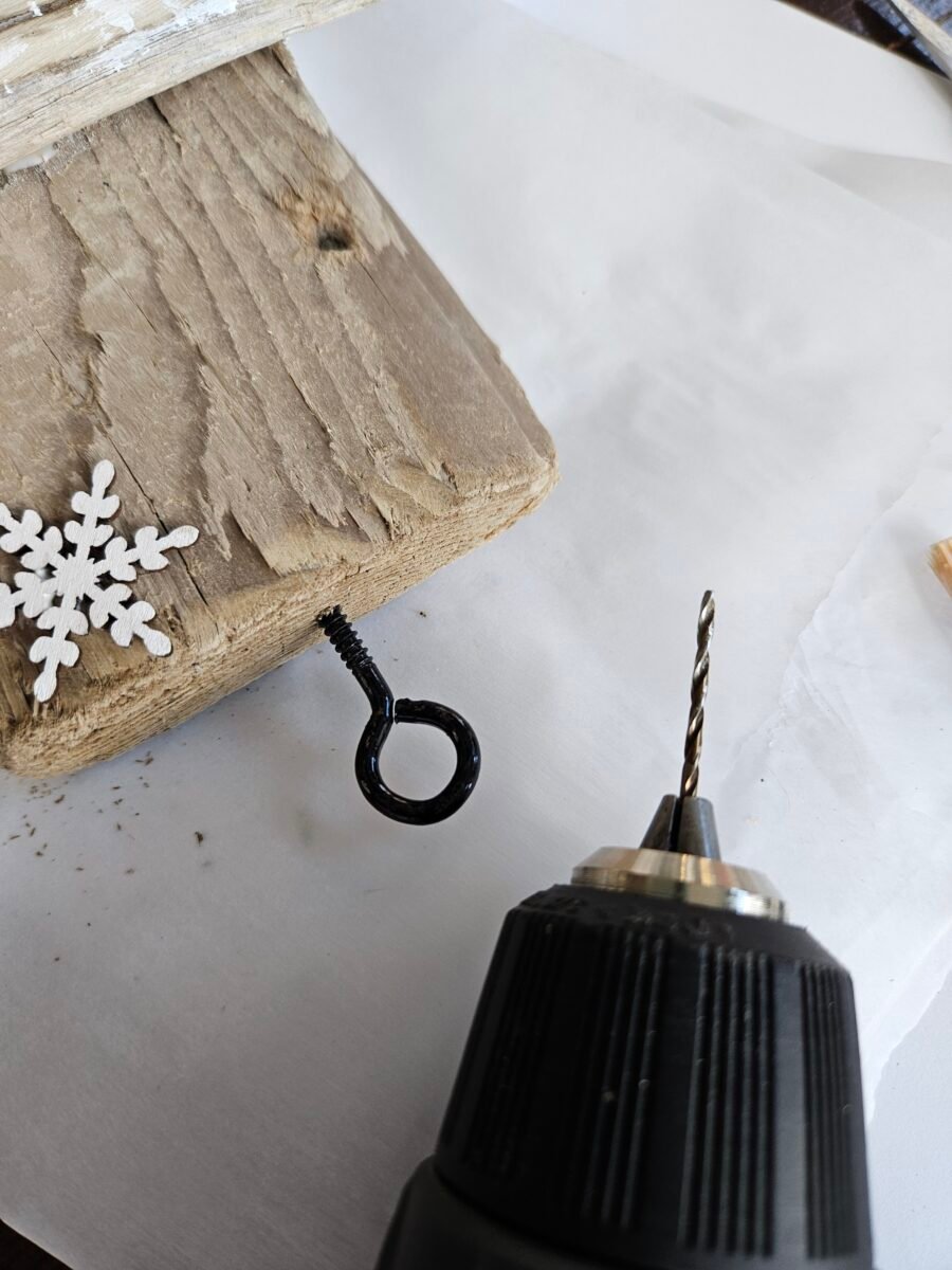 Attaching an eyelet screw to a piece of scrap wood.
