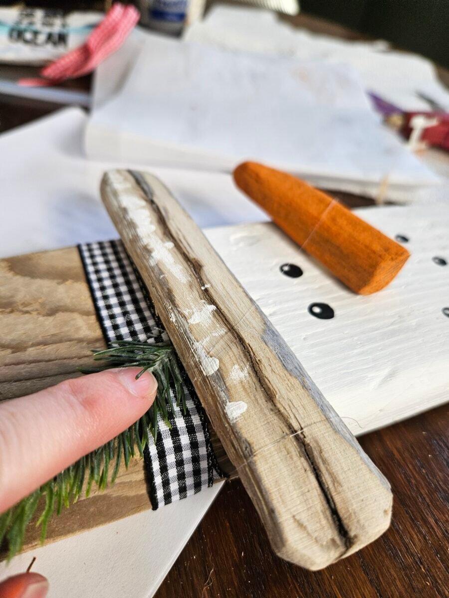 Gluing ribbon to the snowman hat.