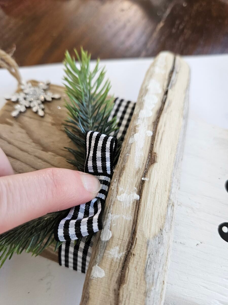 Attaching a ribbon bow to the snowman hat.