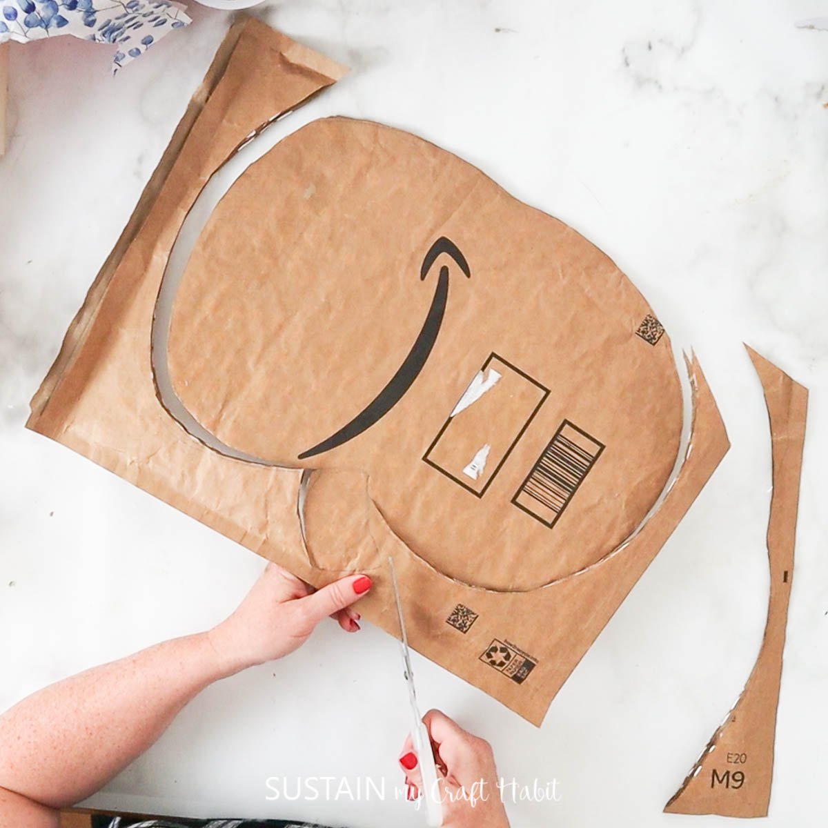 Cutting a pumpkin shape from Amazon packaging. 