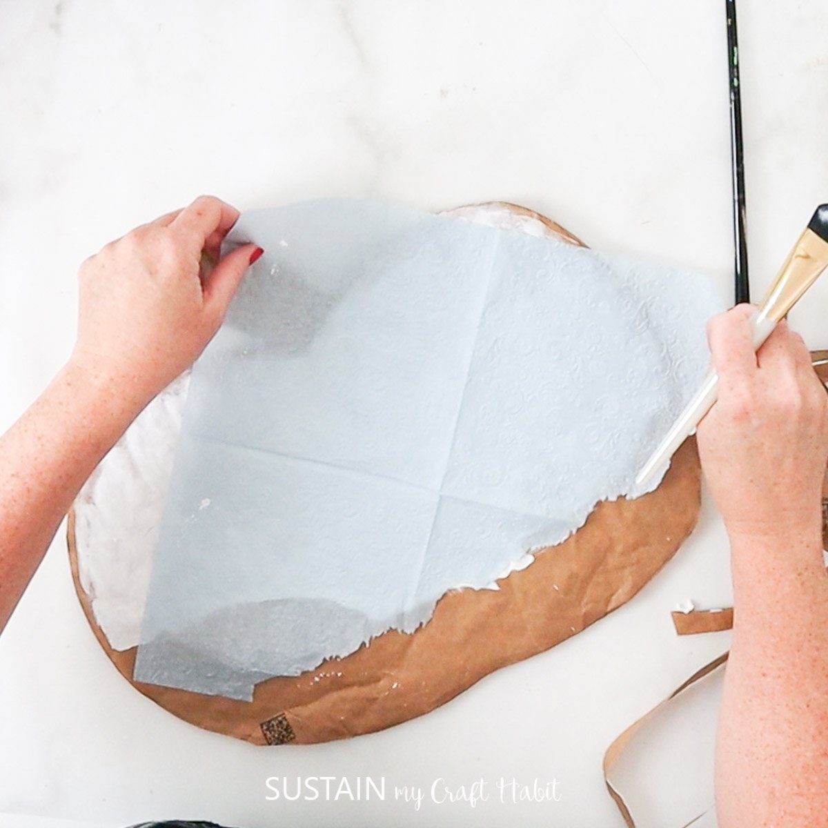 Laying blue tissue paper over the paint. 