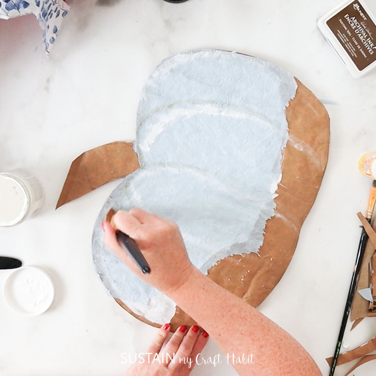 Painting "ribs" onto the pumpkin.