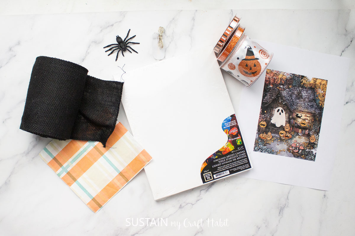 Materials needed to make a Halloween busted canvas including fabric, canvas, napkin and ghost image.