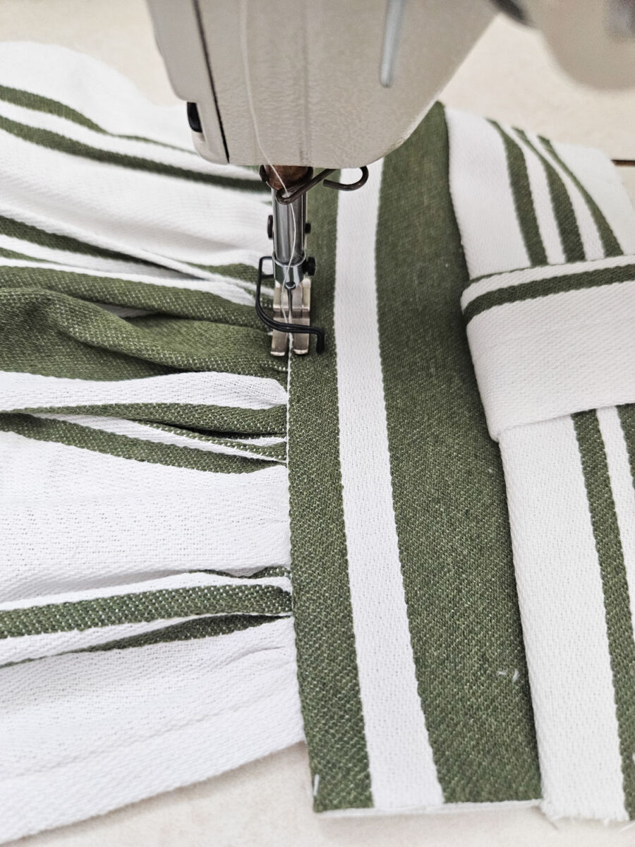 Sewing two pieces of the tea towel together.