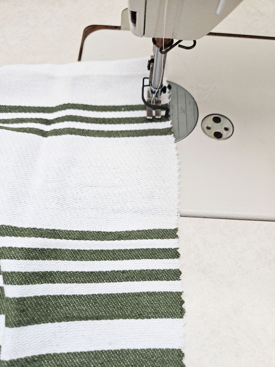 Sewing the end of the tea towel.