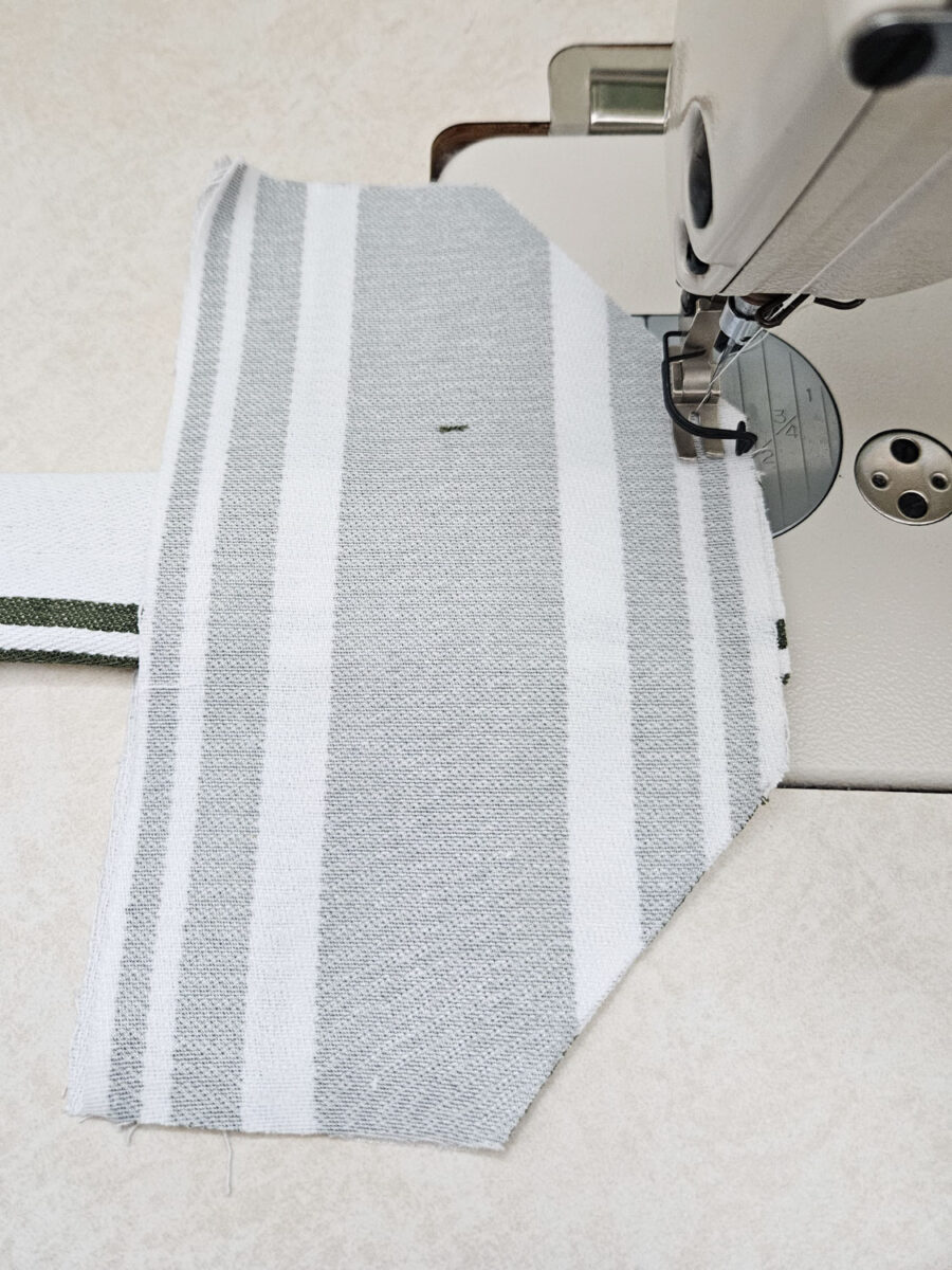 Aligning the tea towel and stitching the edge.