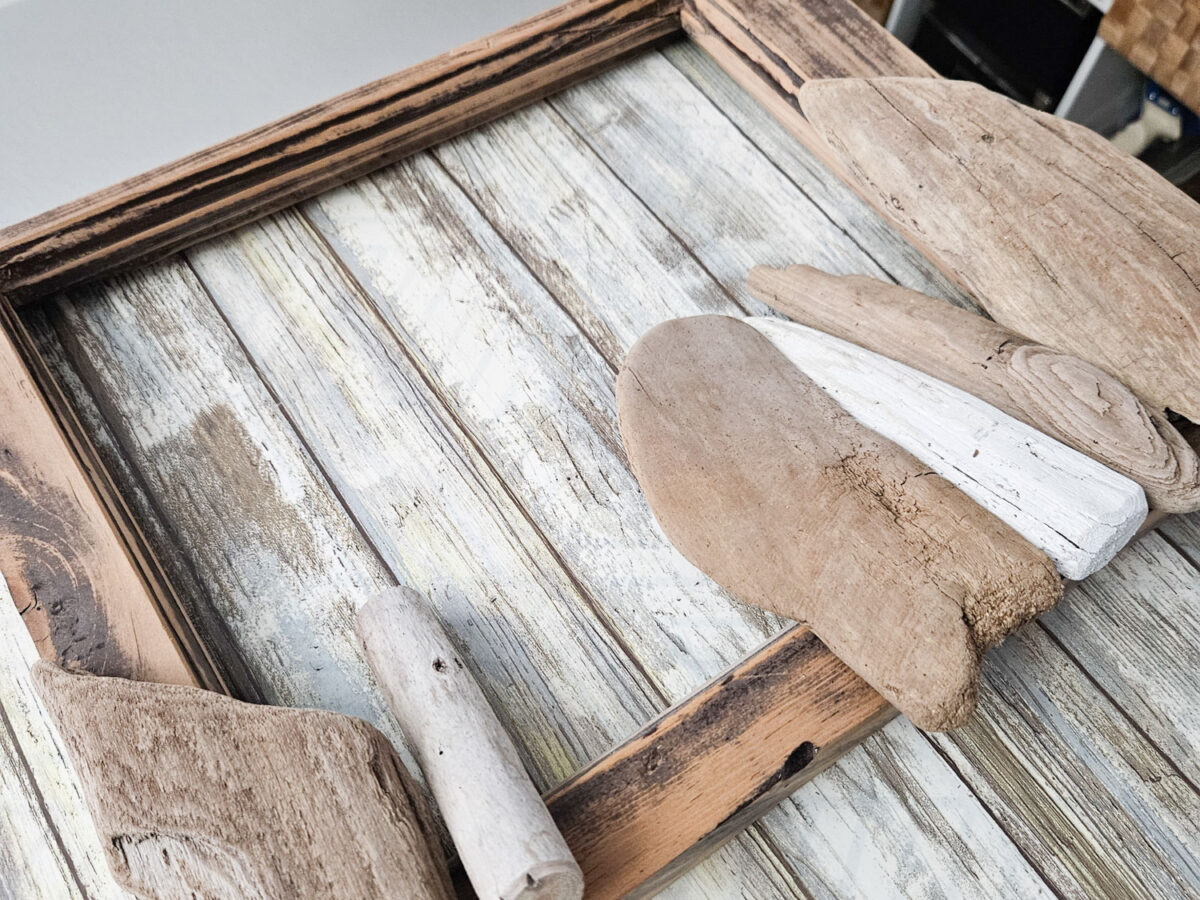 Laying driftwood pieces onto a frame.