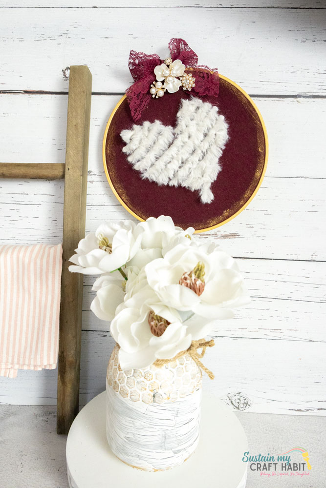 Embroidered yarn heart decor next to decor.