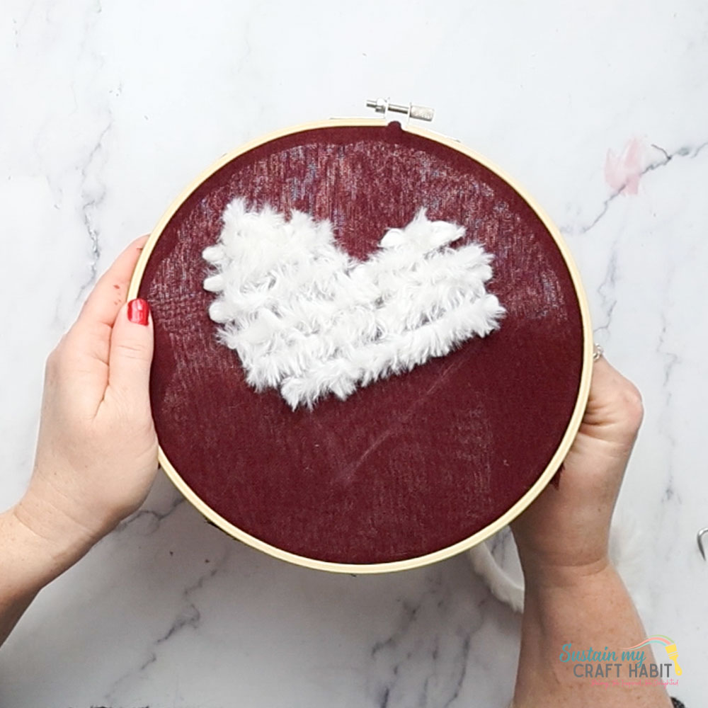 Forming a heart shape with the yarn.