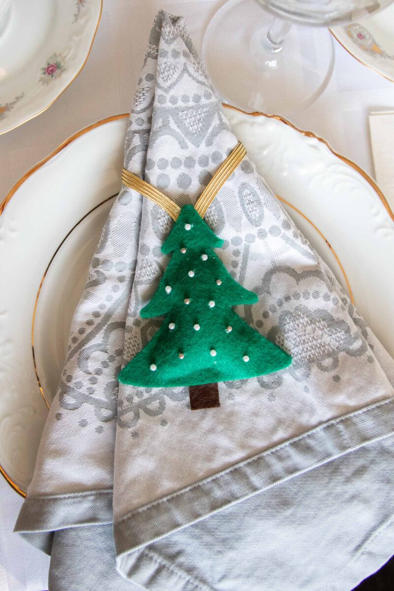 DIY Christmas tree napkin ring placed on a napkin.