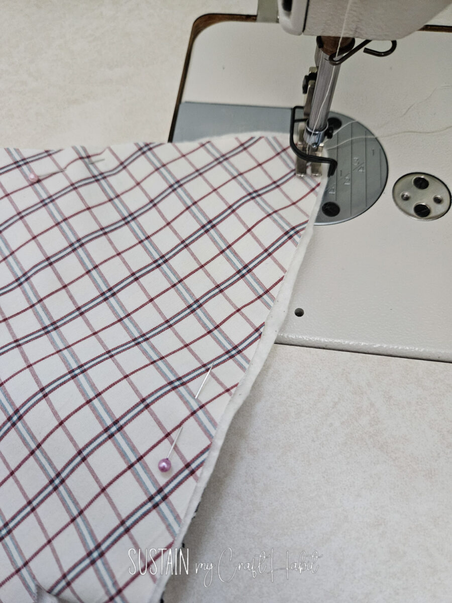 Sewing machine stitching fabric together.