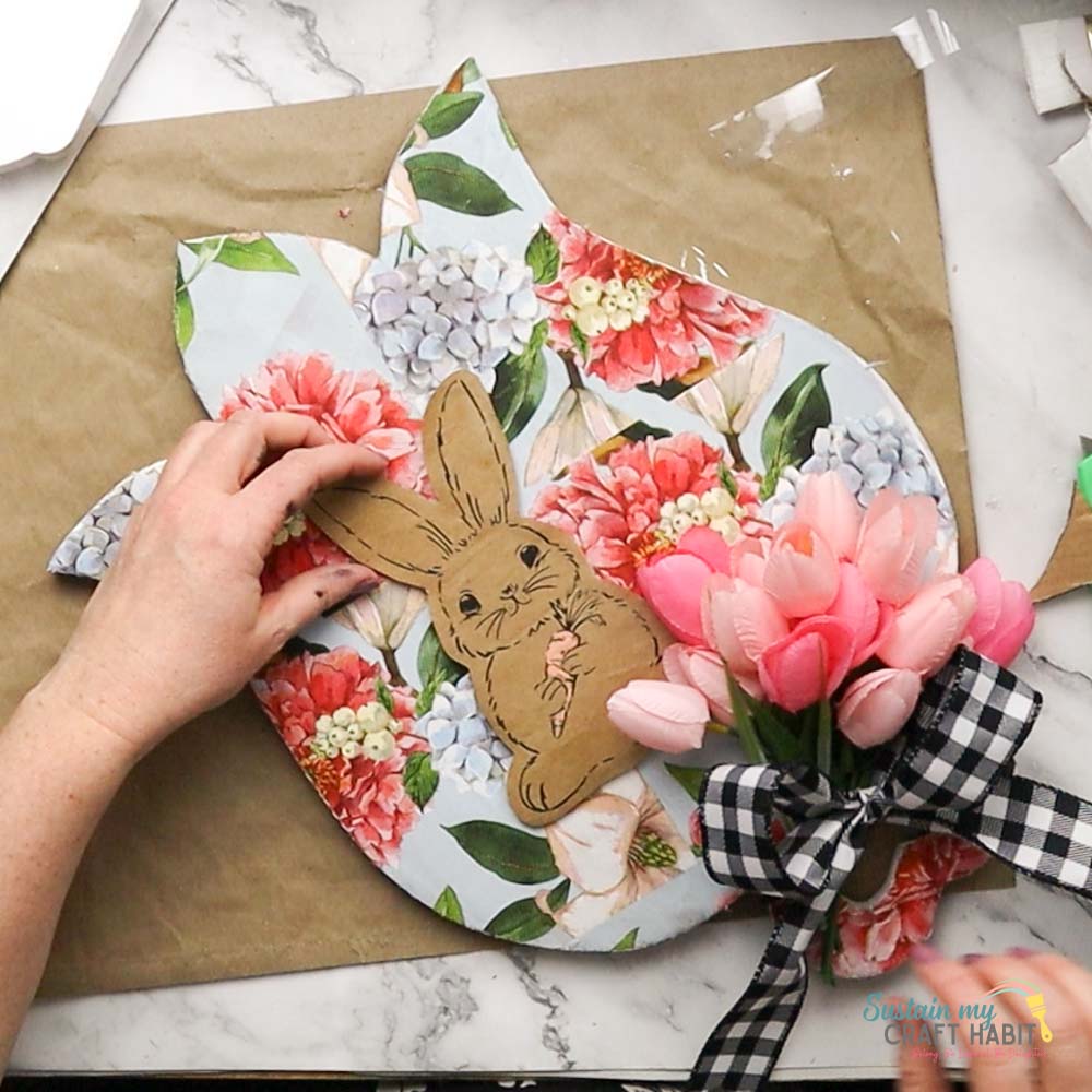 Adding bunny image to tulip board with decoupage.