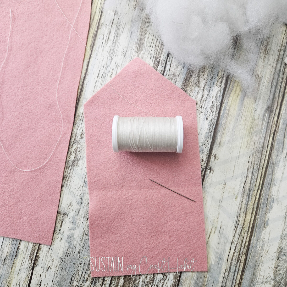 Piece of felt fabric with a thread and needle.