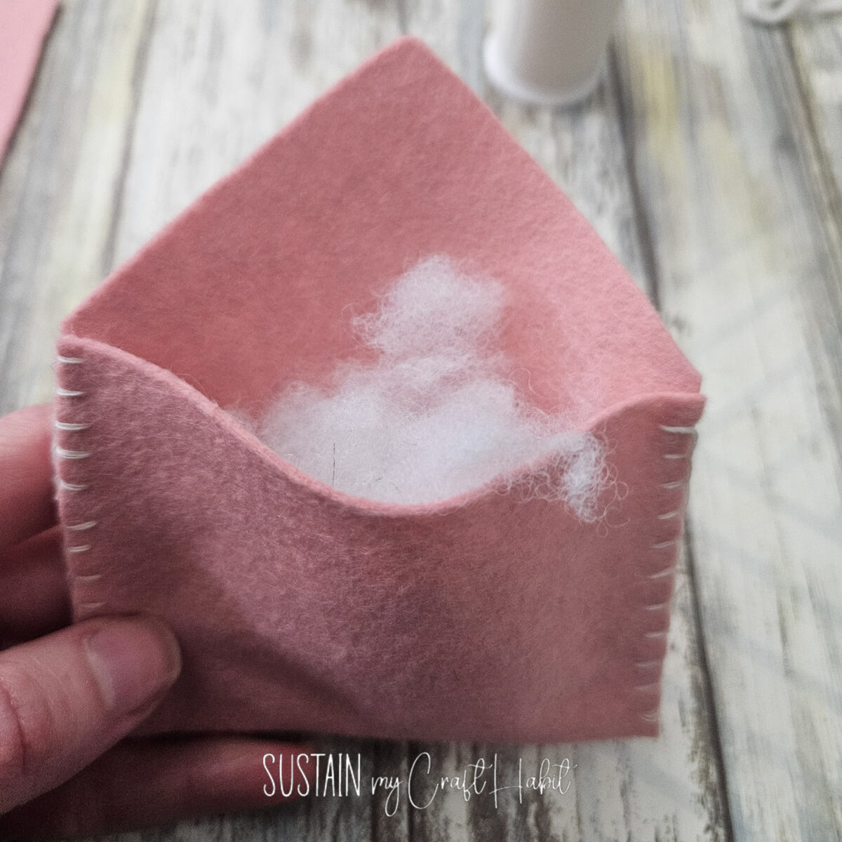 Stuffing polyfill into a felt fabric envelope.