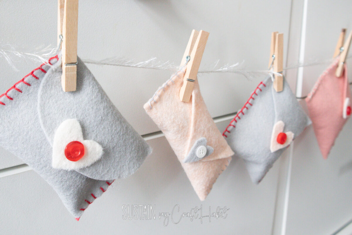 Valentine's day felt envelope garland hanging on a string with clothespins.