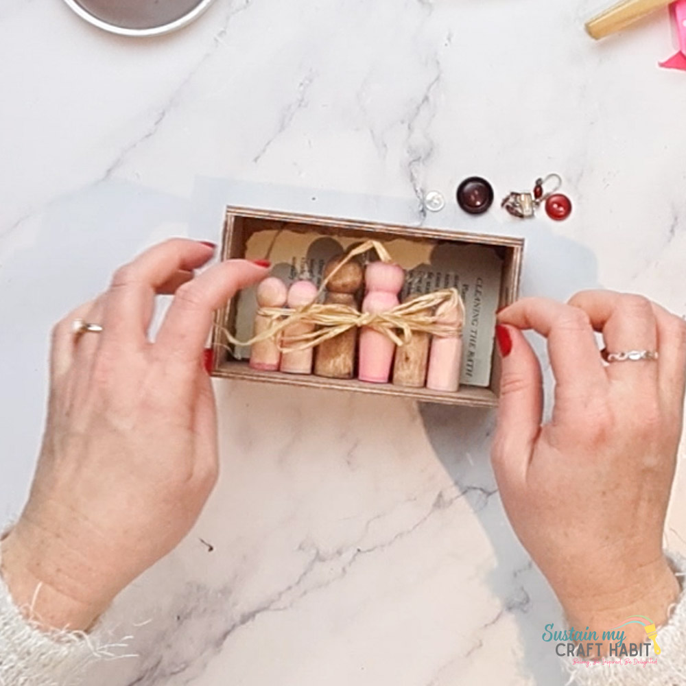 Gluing ribbon to the wooden peg family. 