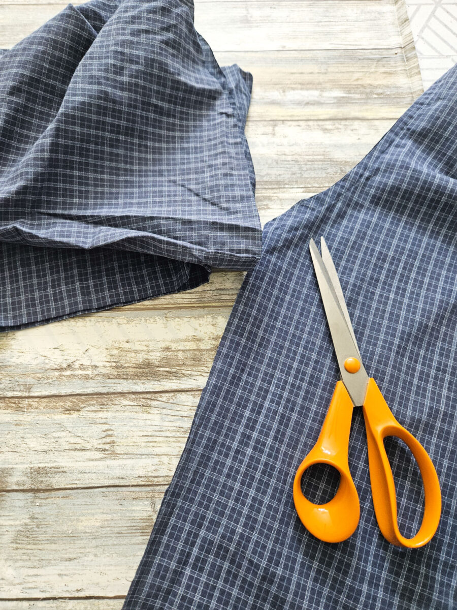 Fabric scissors next to a cut men's shirt.