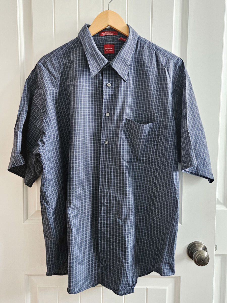Men's button up shirt on a hanger.