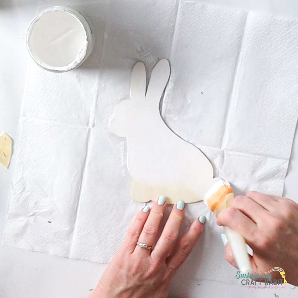 Painting a bunny cutout with white paint. 