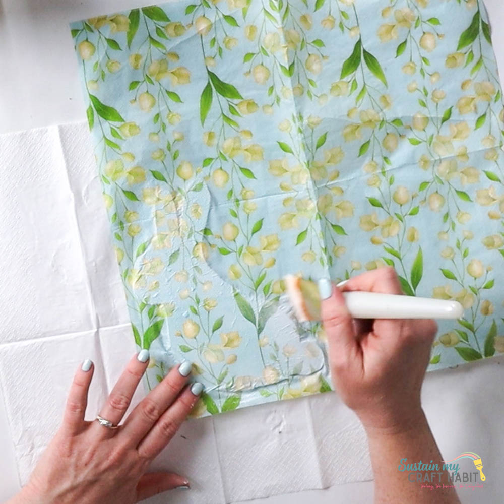 Gluing a paper napkin over the bunny cut out. 