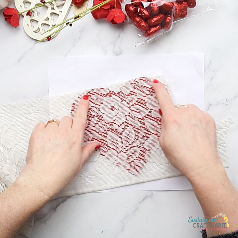 Gluing lace fabric onto a heart.
