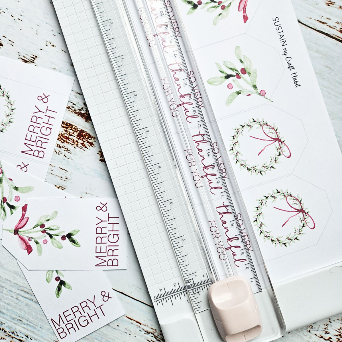 Using a paper trimmer to cut out the printable holiday gift tags.