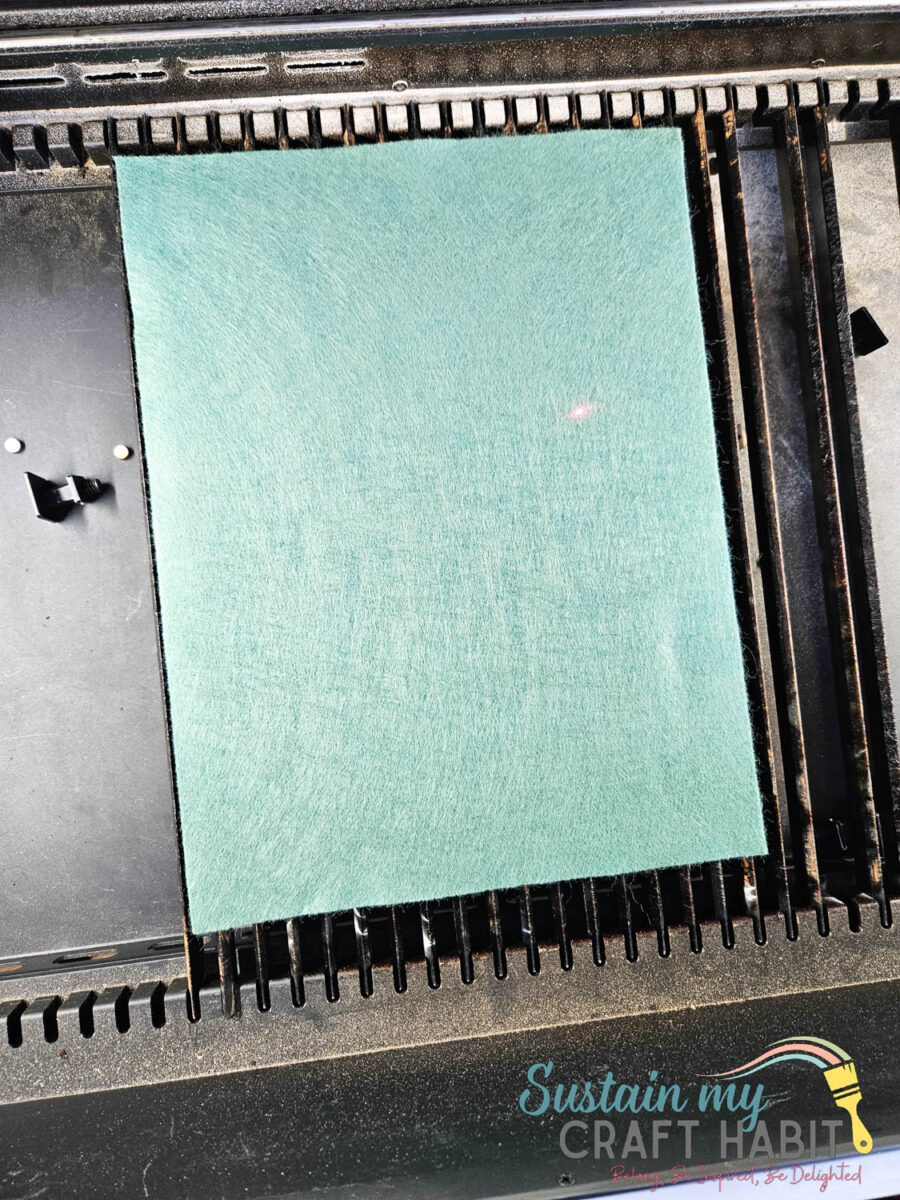 Placing a felt sheet on the Xtool machine.
