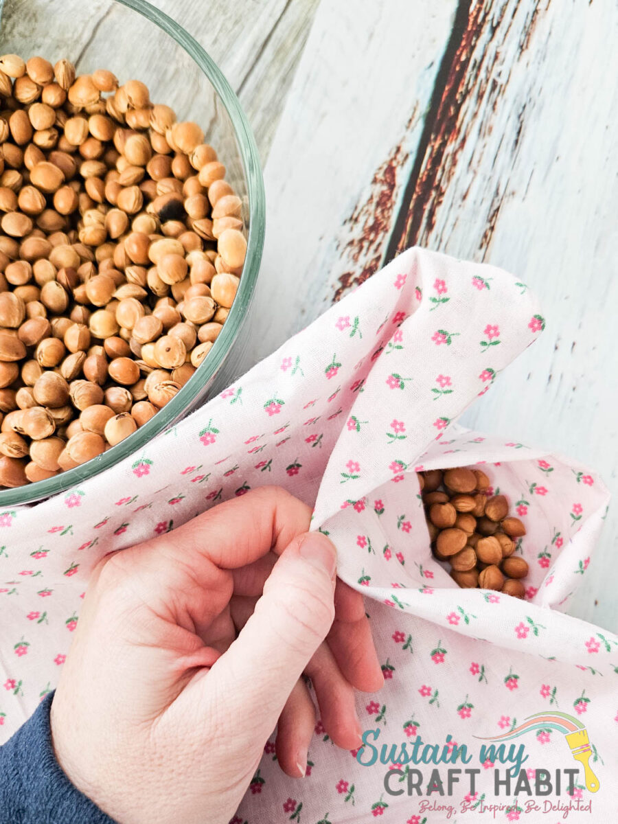 Filling heat bag with cherry pits.