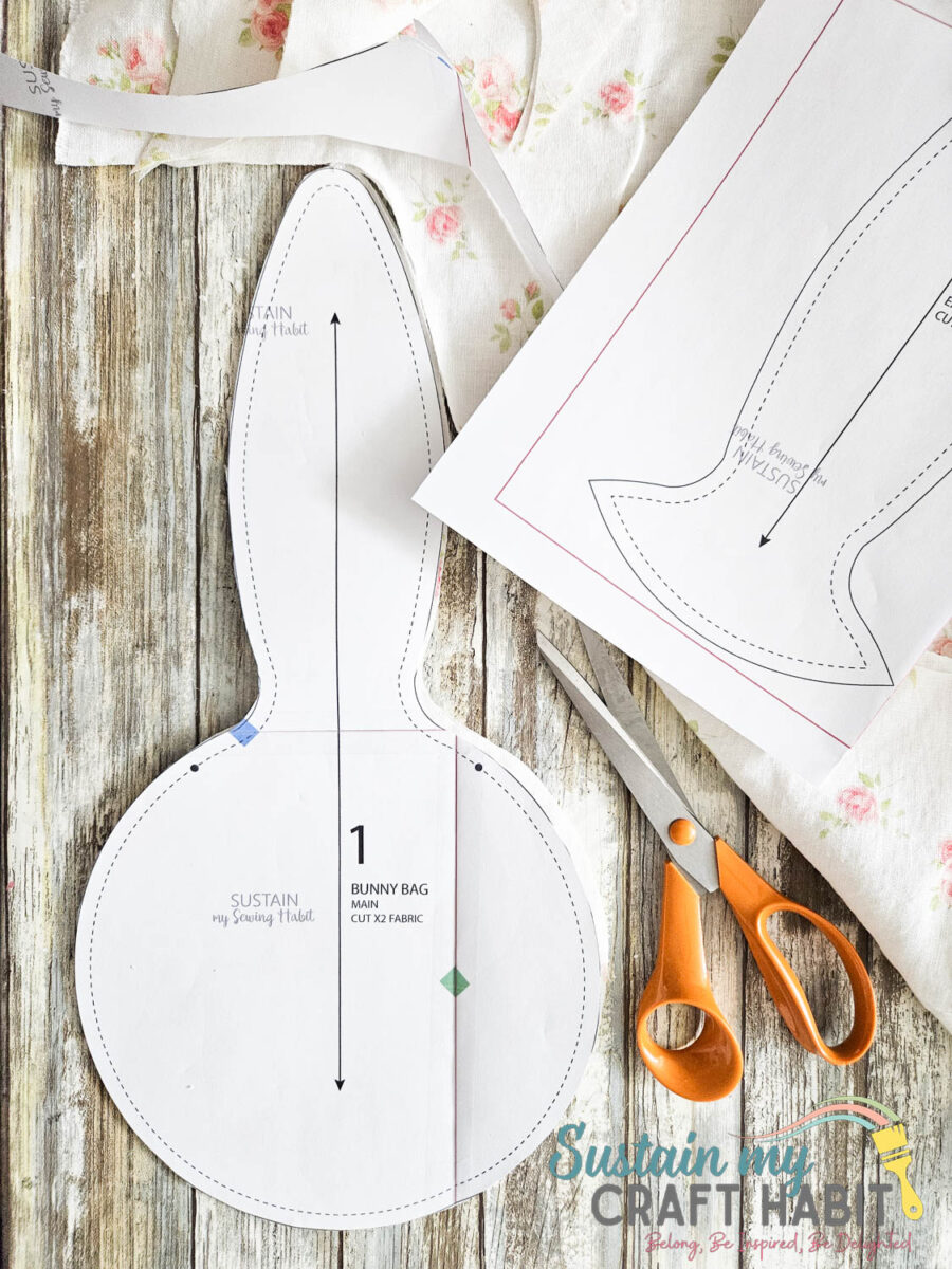 Materials needed to make an Easter bunny gift bag including printable bunny, scissors and fabric.