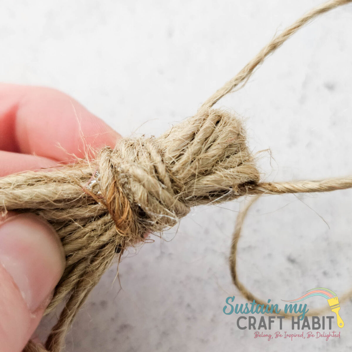 Looping through twine through the top of a twine loop. 