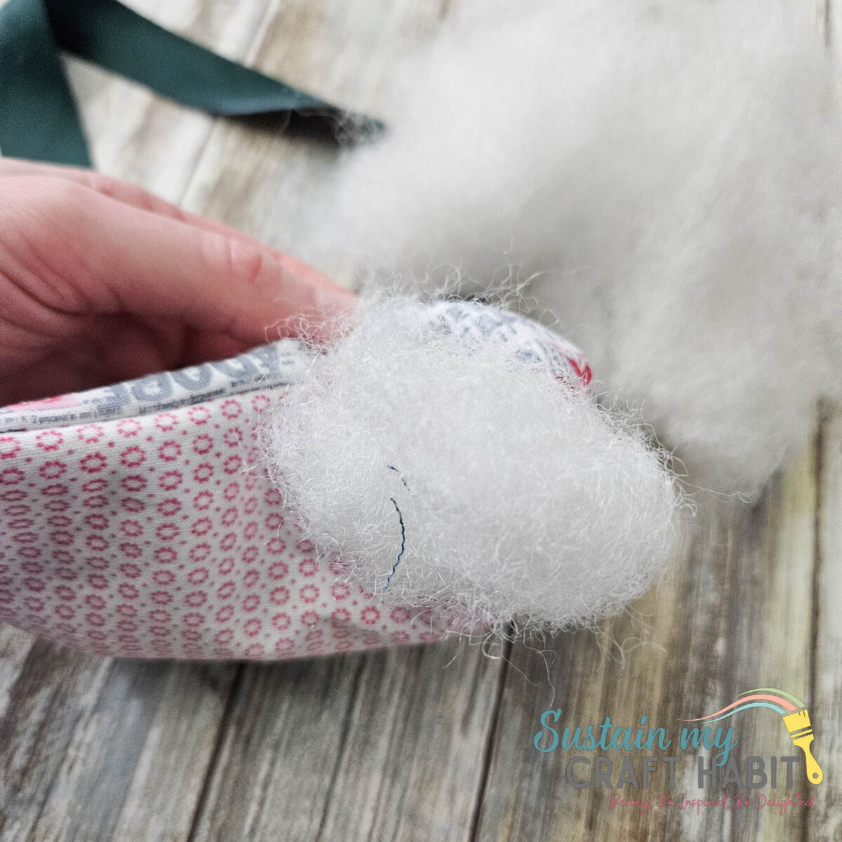 Filling the inside of tooth fairy pillow with stuffing. 