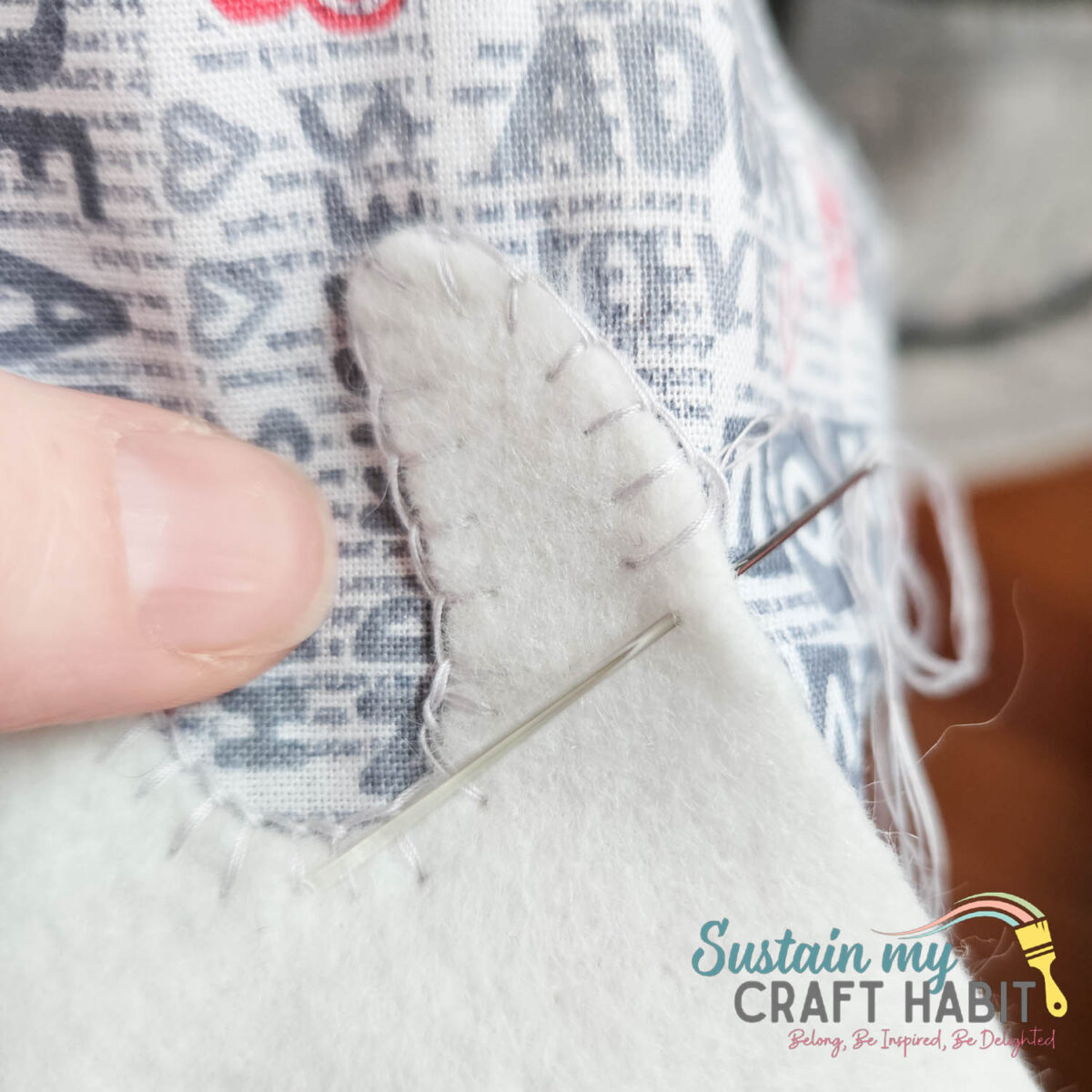 Hand sewing tooth cut out onto fabric. 