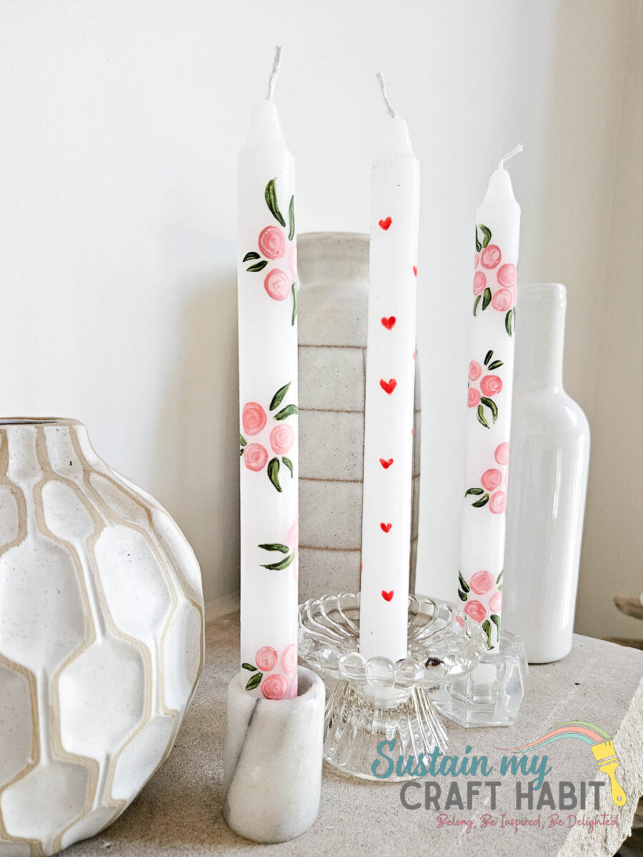 Hand painted candles displayed with decor.