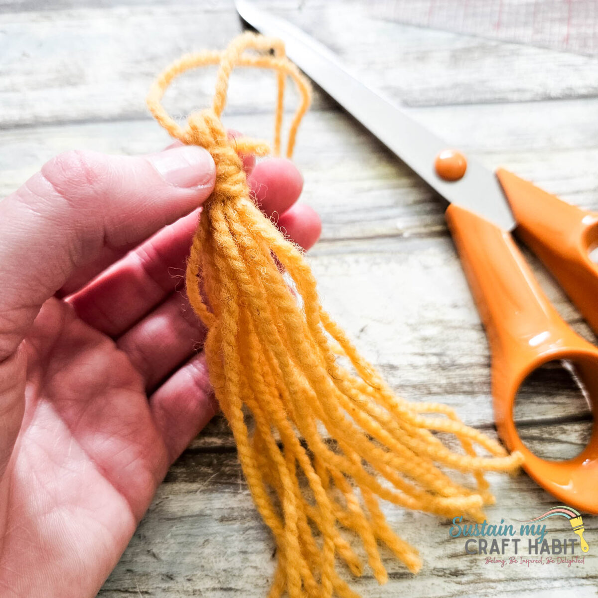Tying a yellow tassel.