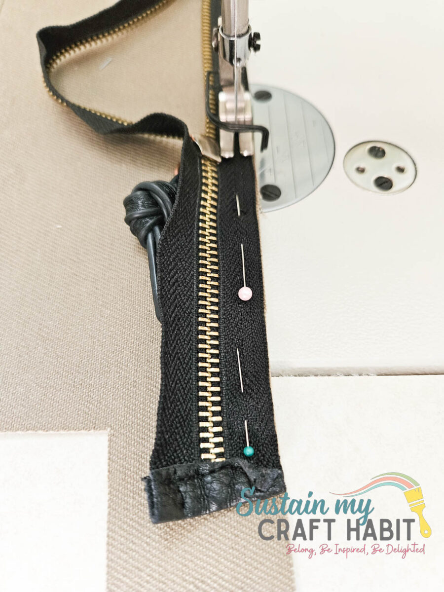 Sewing a zipper onto the travel bag.