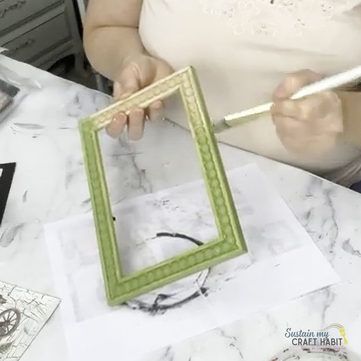 Painting a Dollar Tree frame with green paint.