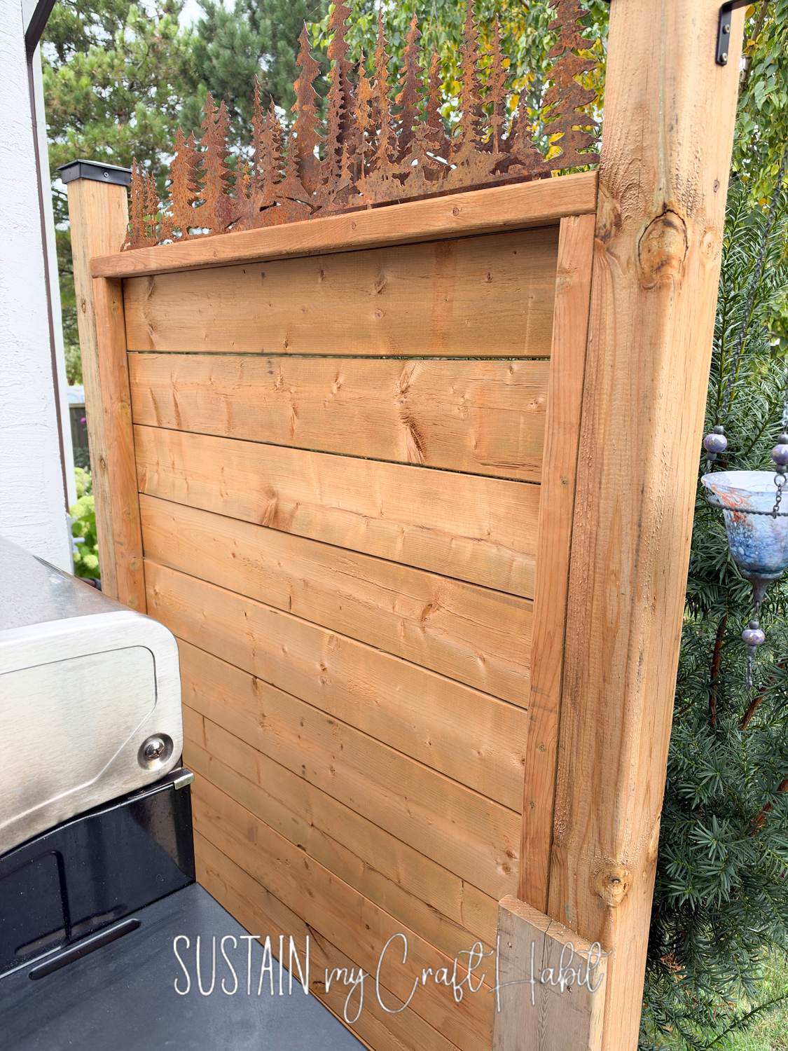 Temporary outdoor privacy wall with decorative top.